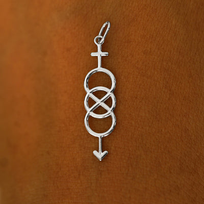A solid 14k white gold Bisexual Symbol Charm resting on the back of a model's hand