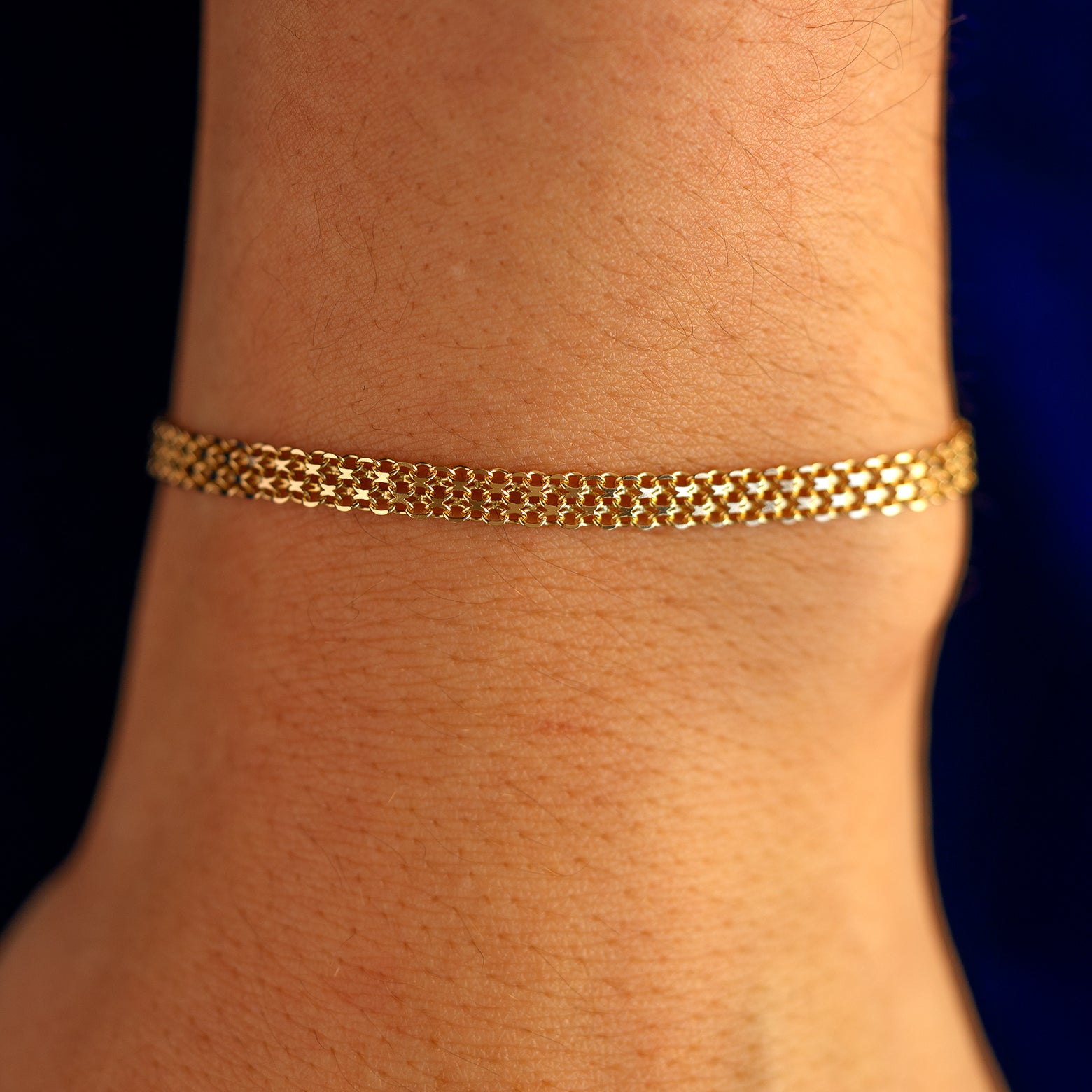Close up view of a models wrist wearing a solid 14k yellow gold Bismark Chain Bracelet