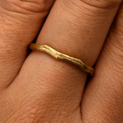 Close up view of a model's fingers wearing a 14k yellow gold Branch Band