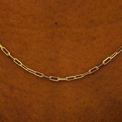Close up view of a model in a white shirt wearing a solid yellow gold Butch Chain
