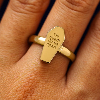 Close up view of a model's hand wearing a yellow gold Coffin Ring in the closed position