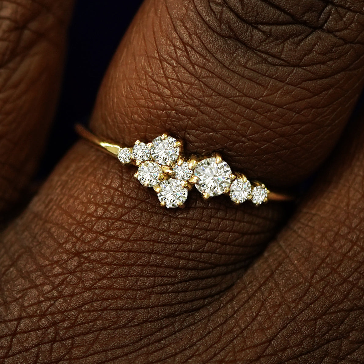 Close up view of a model's fingers wearing a 14k yellow gold Diamond Cluster Ring