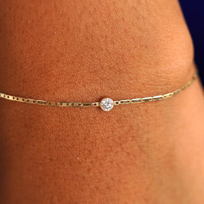 Close up view of a model's wrist wearing a solid yellow gold Diamond Bracelet