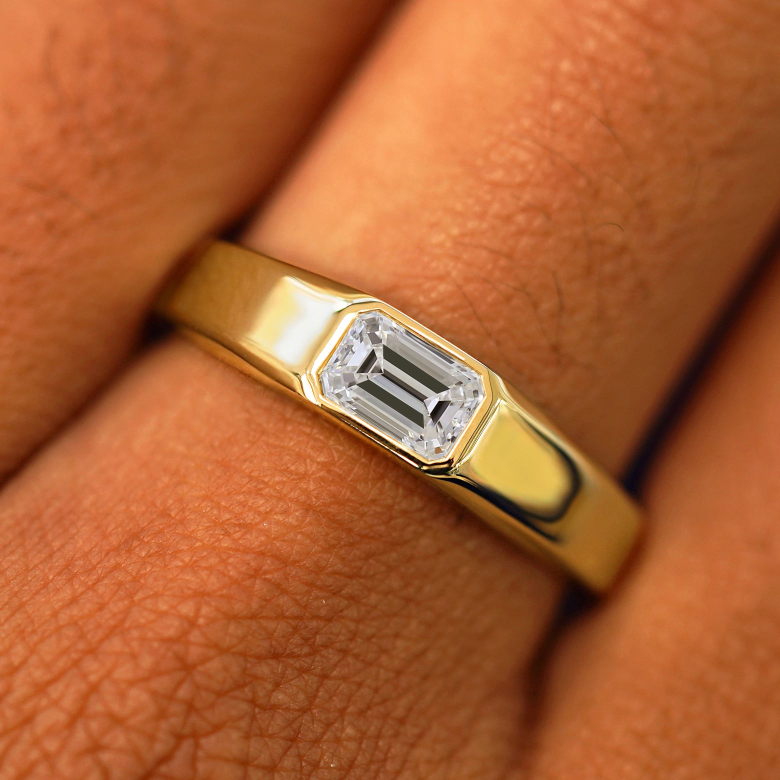 Close up view of a model's fingers wearing a 14k yellow gold Emerald Cut Lab Created Diamond Signet Ring