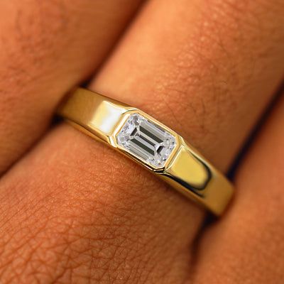 Close up view of a model's fingers wearing a 14k yellow gold Emerald Cut Lab Created Diamond Signet Ring