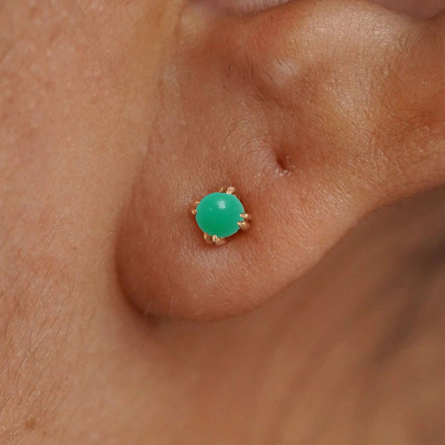 Close up view of a model's ear wearing a 14k yellow gold Green Jade Earring