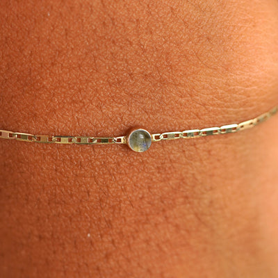 Close up view of a models wrist wearing 14k yellow gold Labradorite Bracelet