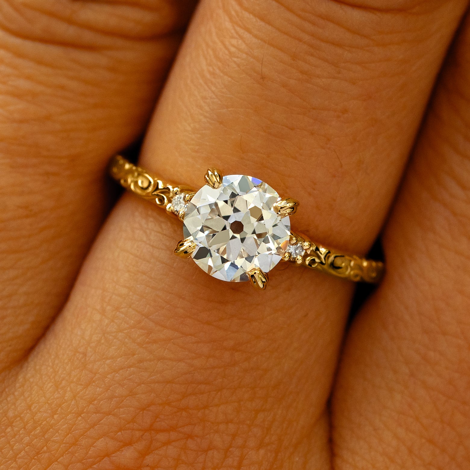 A solid 14k yellow gold Old Mine Cut Lab Diamond Filigree Ring on a model's finger