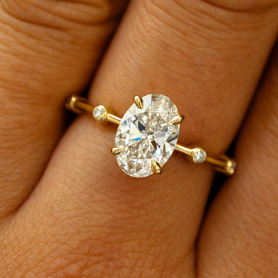 A solid 14k yellow gold Oval Lab Diamond Bubble Ring on a model's finger