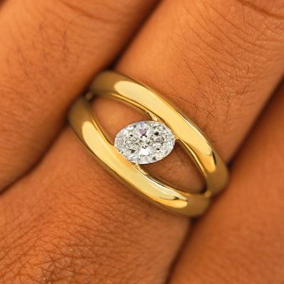 Close up view of a model's fingers wearing a 14k yellow gold Oval Lab Diamond Tension Ring