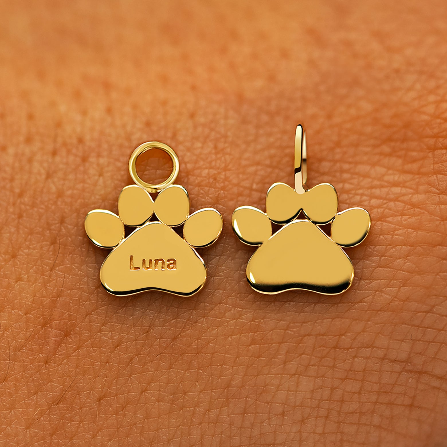 Two solid 14k yellow gold Paw Charms showing the for chain and the for earring options