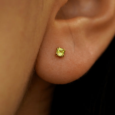 Close up view of a model's ear wearing a 14k yellow gold Peridot Earring