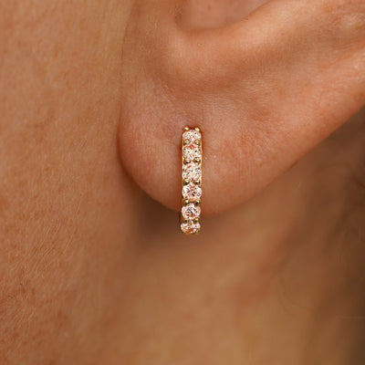 Close up view of a model's ear wearing a yellow gold Small Pink Lab Diamond Huggie Hoop