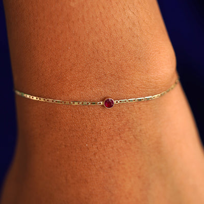 A model's wrist wearing a 14 karat yellow gold Ruby Bracelet