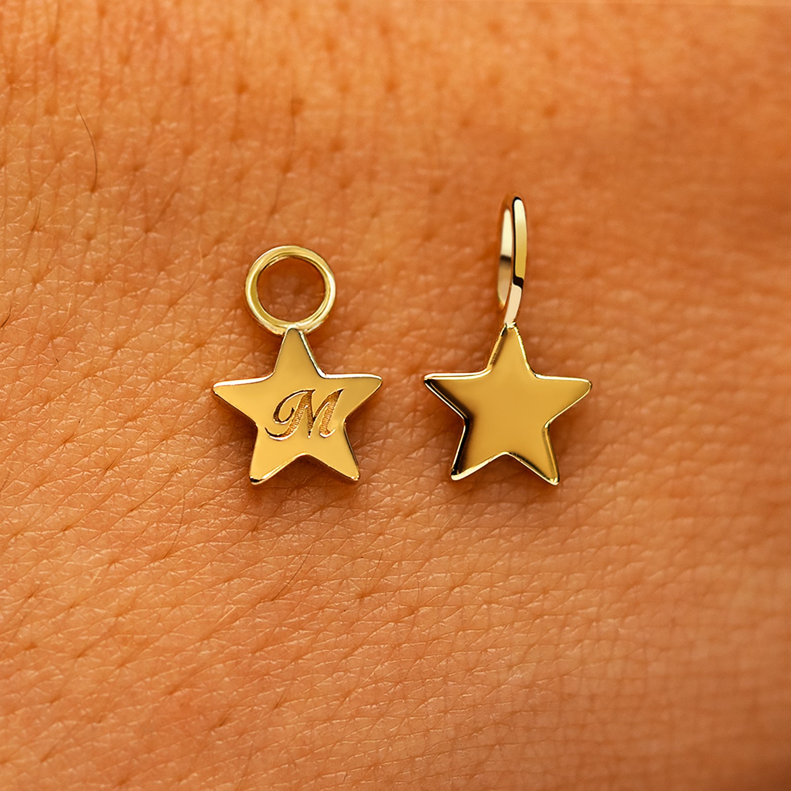 Two solid 14k yellow gold Star Charms showing the for chain and the for earring options