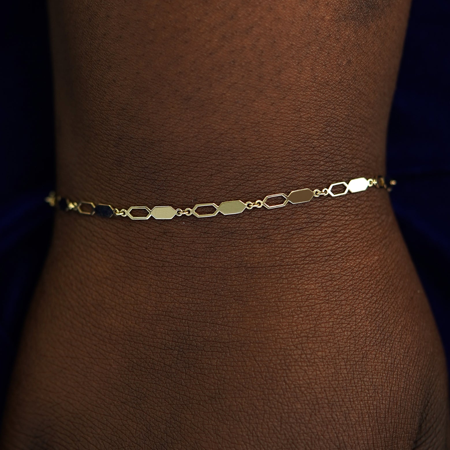 A model's wrist wearing a solid gold Tanlah Bracelet