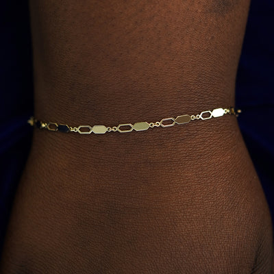 A model's wrist wearing a solid gold Tanlah Bracelet