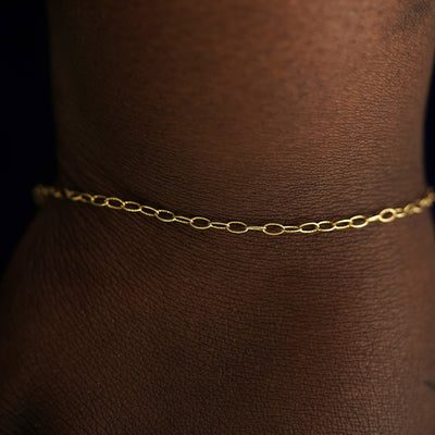 A model's wrist wearing a solid yellow gold Veren Bracelet