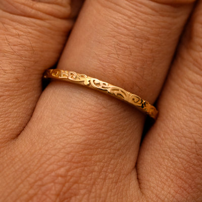 Close up view of a model's fingers wearing a 14k yellow gold Thin Filigree Band