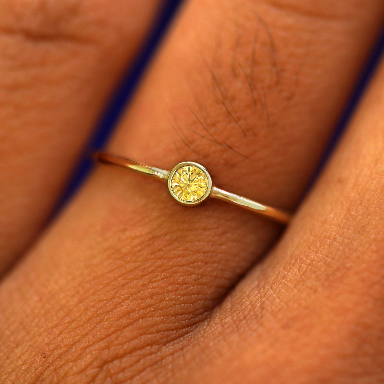 Close up view of a model's fingers wearing a 14k yellow gold Yellow Diamond Ring
