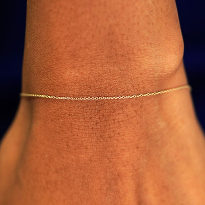 A model's wrist wearing a solid 14k yellow gold Cable Bracelet